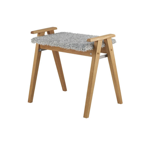 Fotpall i ek med grå fårskinnssits och snedställda ben i skandinavisk design