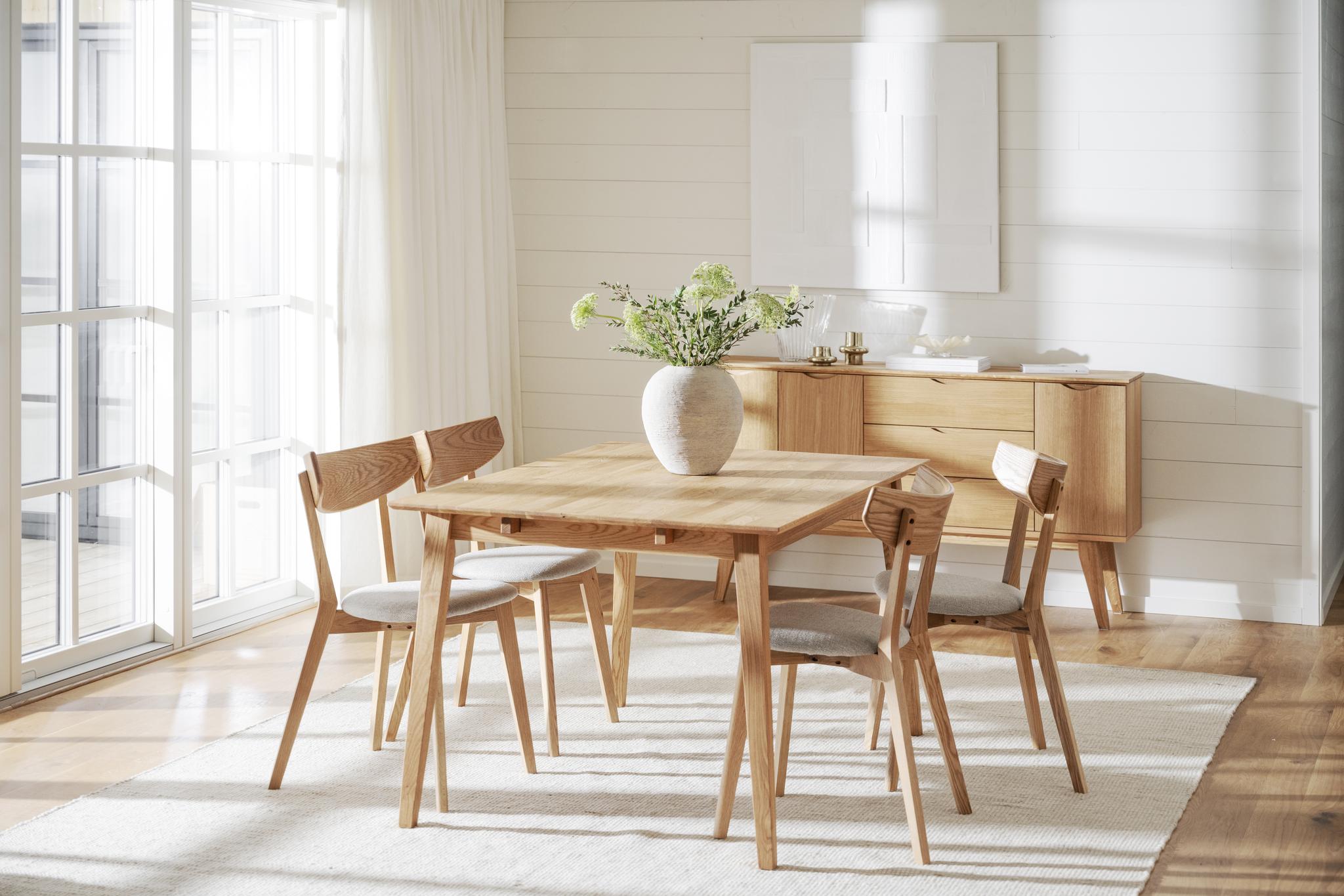Matgrupp i ljust trä med fyra stolar och sideboard i skandinavisk stil med naturligt ljusinsläpp