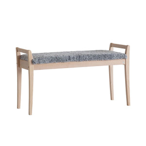 Bänk i ljust trä med grå fårskinnsdyna, skandinavisk design med smala ben och armstöd