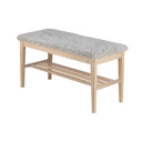 Hallbänk i ljust trä med grå sittdyna i fårskinn och praktisk skohylla under sitsen