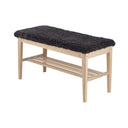 Hallbänk i ljust trä med svart fårskinnsdyna och hylla för skoförvaring