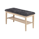Hallbänk i ljust trä med grå fluffig sits och förvaringshylla under