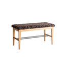 Hallbänk i ljust trä med brun fuskpälsöverdrag och metallhylla för skoförvaring