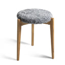 Pall med grå fårskinnsdyna och ben i ek, rund sittmöbel i skandinavisk design