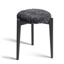 Rund pall med svart träram och grå fluffig sits i fårskinn