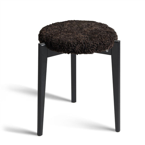 Rund pall med svarta fårskinnsdyna och svarta träben