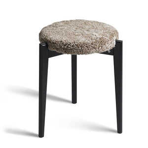 Pall med svarta träben och rund sits i beige/grå teddy-textil