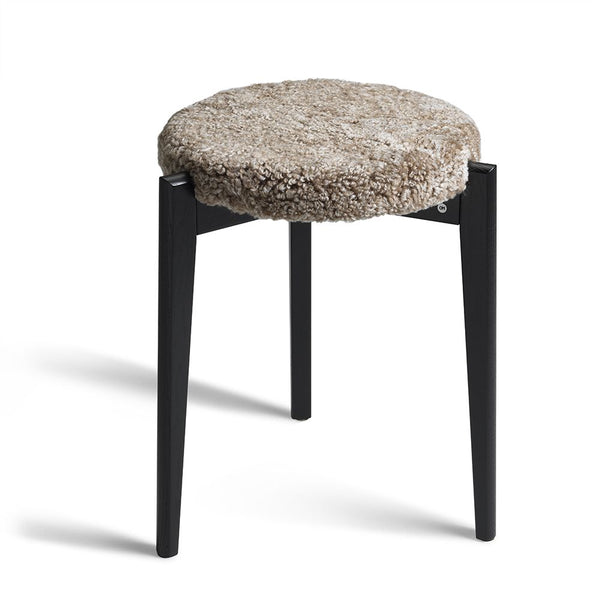 Pall med svarta träben och rund sits i beige/grå teddy-textil