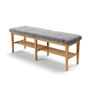 Hallbänk i ek med grå fårskinnsdyna och skoförvaring under sittdynan