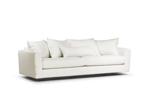 Vit modern soffa med lös dyna och mjuka kuddar på svart sockel mot vit bakgrund