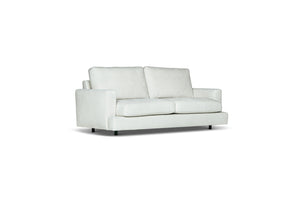 Vit tvåsitssoffa med raka armstöd och lösa kuddar på ljus bakgrund