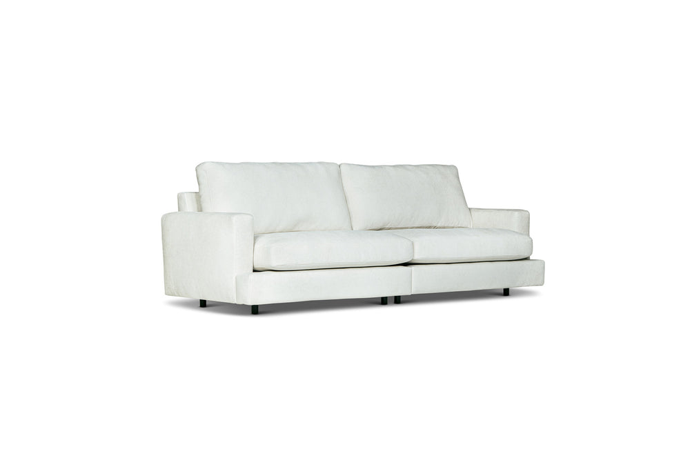 Vit tvåsits soffa med rena linjer och låga ben i modern skandinavisk design