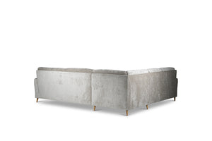 Grå hörnsoffa i sammet sedd bakifrån med träben och mjuka dynor