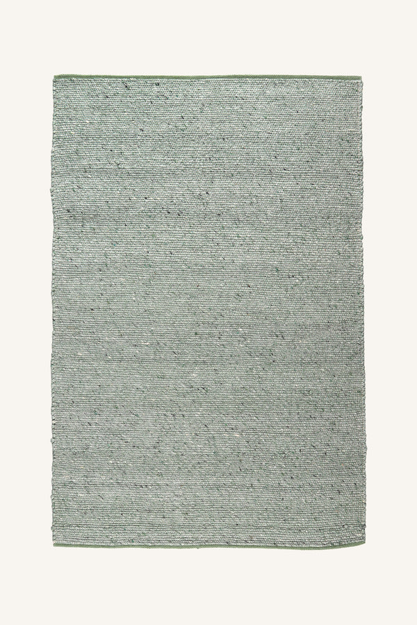 Handvävd matta i gröna och beige nyanser med naturlig textur och horisontal vävning