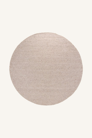 Rund matta i beige och ljusgrå toner med handvävd textur, ovanifrån mot ljus bakgrund