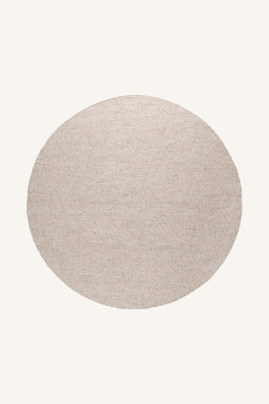 Rund matta i ljusbeige färg med naturlig textur, ovanifrån fotograferad mot ljus bakgrund