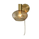 Vägglampa i mässing med rund amber glasskärm och dragsladd