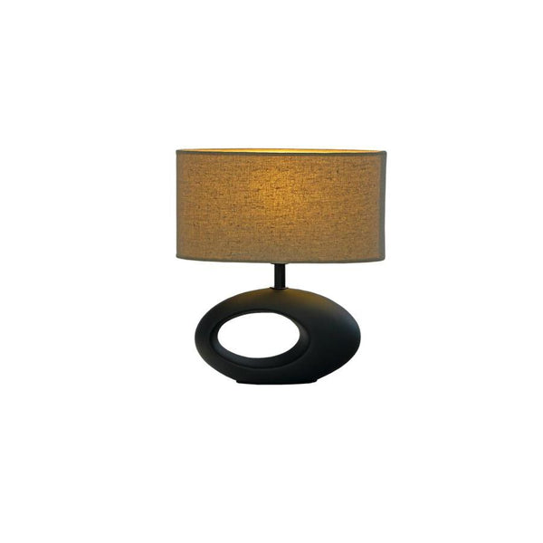 Bordslampa med oval svart fot och beige lampskärm i tyg