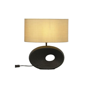 Bordslampa med oval mörkgrå fot och beige lampskärm i tyg