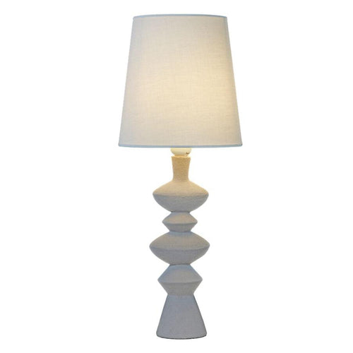 Bordslampa med vit textinskärm och skulptural fot i grå-beige nyanser