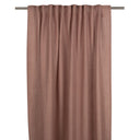 Ljust rostrosa gardin i linnetyg hängande på en gardinstång med veck och natural struktur