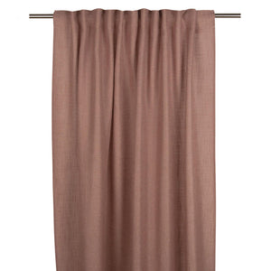 Ljust rostrosa gardin i linnetyg hängande på en gardinstång med veck och natural struktur