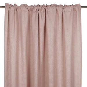 Rosa linnegardinkappa med rynkband upphängd på gardinstång, visar textilens naturliga struktur och fall