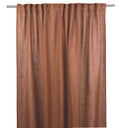 Terrakottafärgad gardin i linne hängande på gardinstång med veck och naturlig struktur