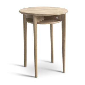 Runt sängbord i ljust trä med hylla och tre ben, skandinavisk design