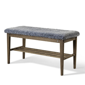 Bänk med grå fårskinnsdyna och trästomme med hylla, perfekt för hall eller sovrum