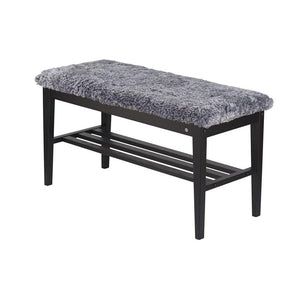 Bänk med grå fuskpäls och svart trästomme med hylla för förvaring
