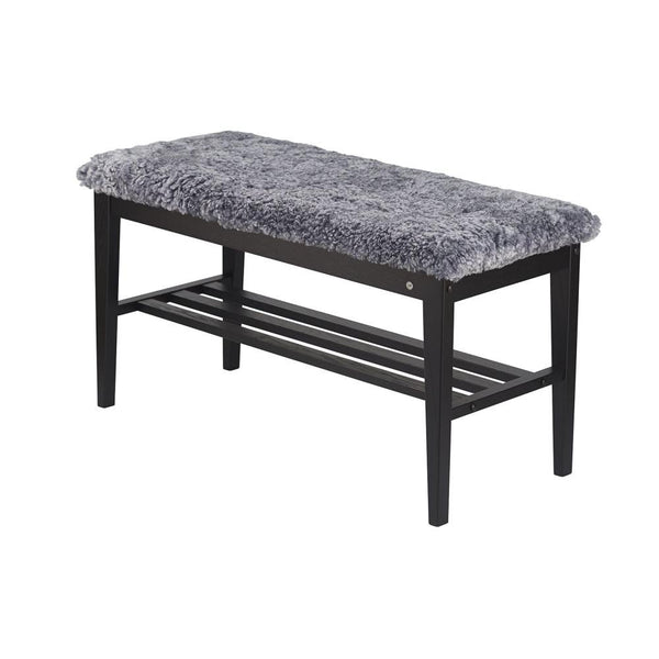 Bänk med grå fuskpäls och svart trästomme med hylla för förvaring