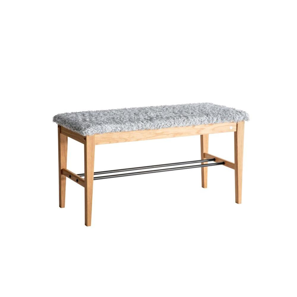 Hallbänk med grå fuskpäls och skoställning i trä och metall