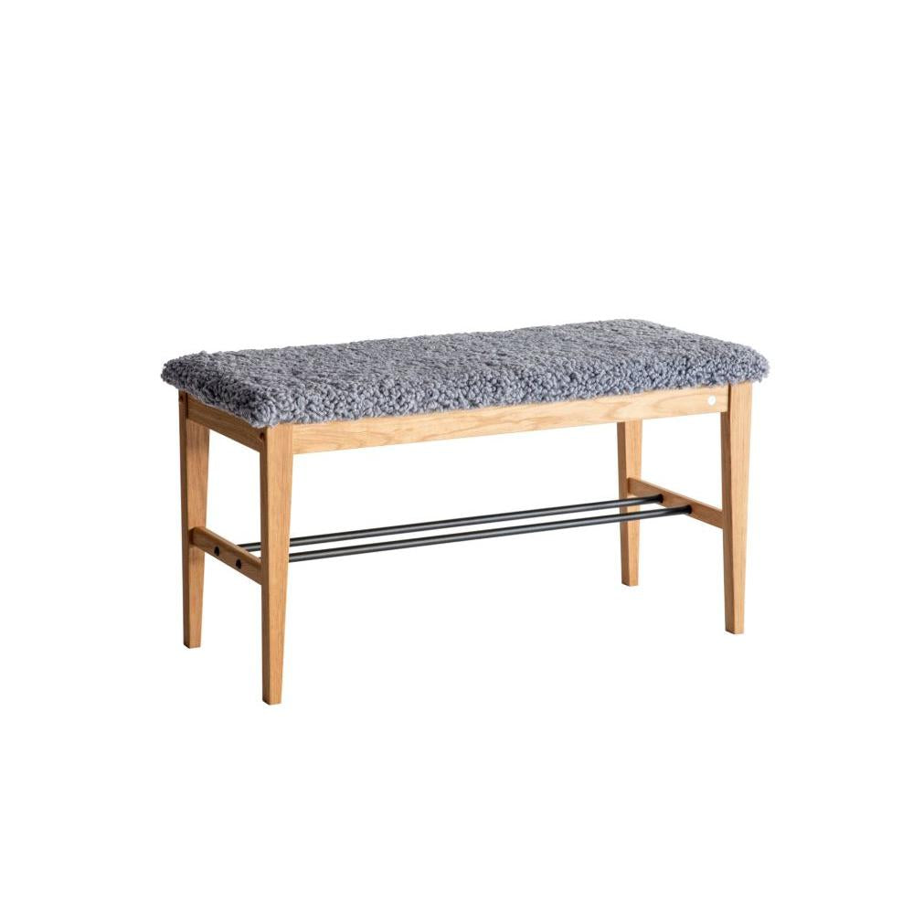 Hallbänk i ek med grå fårskinnsdyna och hylla för skoförvaring