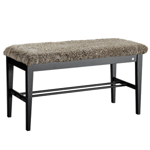 Hallbänk med grå fårskinnsdyna och svart träram med hylla för skoförvaring