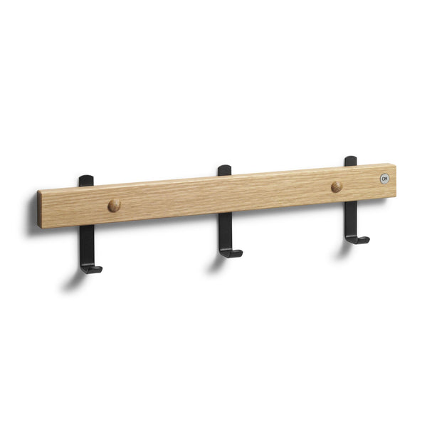 Väggkroklist i ek med tre svarta krokar och två träknoppar för förvaring av kläder och accessoarer