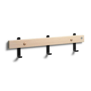 Krokbräda i ljust trä med tre svarta krokar och två träknoppar för väggmontering