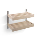 Väggmonterad förvaring med två hyllplan i ljust trä och metallbeslag