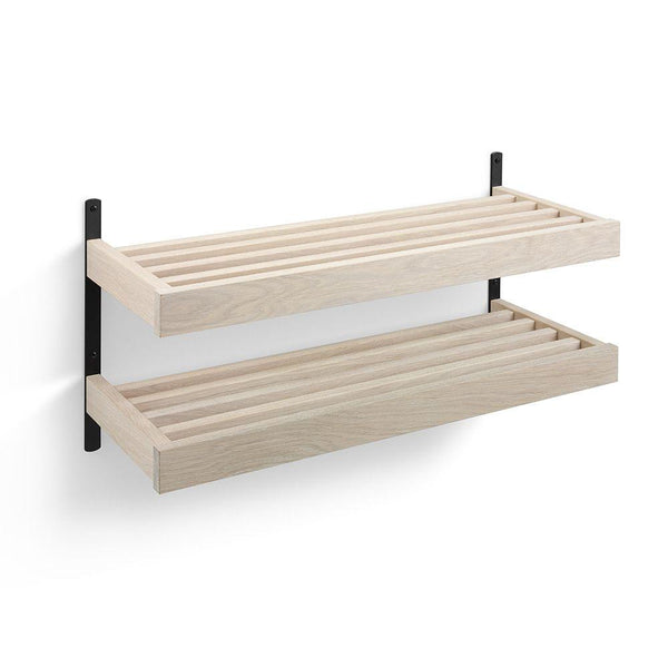 Tvådelad väggmonterad hylla i ljust trä med svarta fästen och spaltad design för förvaring
