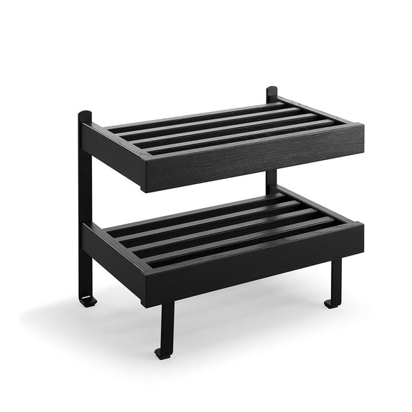 Svart tvåhyllad skoställning i metall med ribbor, moderna designben och kompakt format