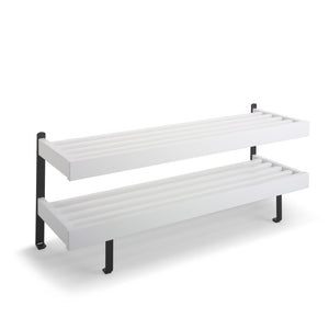 Vit väggmonterad hylla med två nivåer och svarta fästen för förvaring