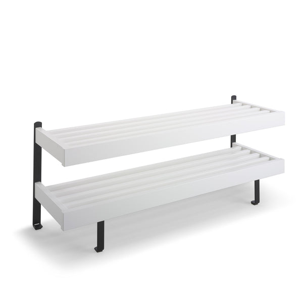 Vit väggmonterad hylla med två nivåer och svarta fästen för förvaring