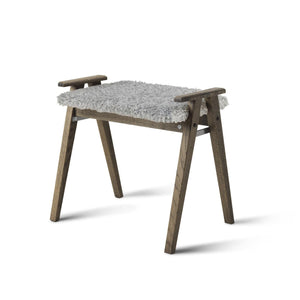 Fotpall i mörkt trä med grå fårskinnsdyna och armstöd i skandinavisk design