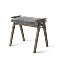 Grå pall med fårskinnssits och träben i smoked ek med praktiskt handtag