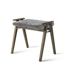 Grå pall med fårskinnssits och träben i smoked ek med praktiskt handtag