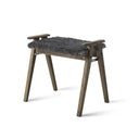 Pall i mörkt trä med grå fårskinnsdyna och handtag, skandinavisk design