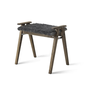 Pall i mörkt trä med grå fårskinnsdyna och handtag, skandinavisk design