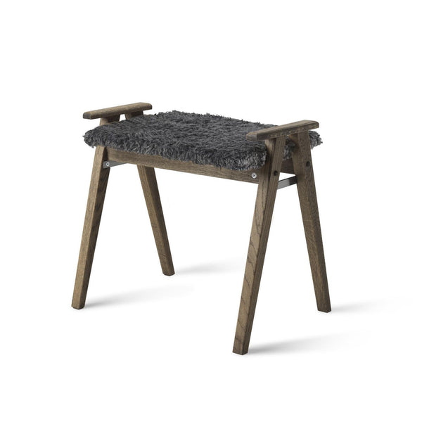 Pall i mörkt trä med grå fårskinnsdyna och handtag, skandinavisk design