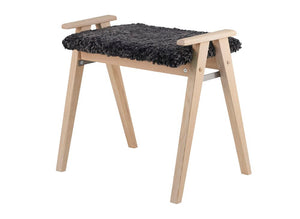 Pall i ljust trä med svart fårskinnssits och armstöd i skandinavisk design