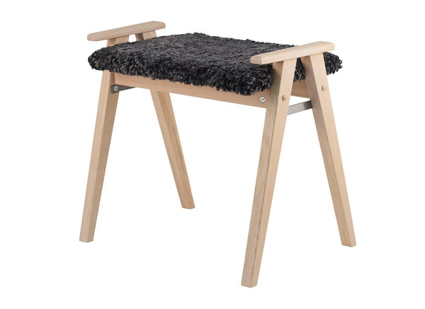 Pall i ljust trä med svart fårskinnssits och armstöd i skandinavisk design